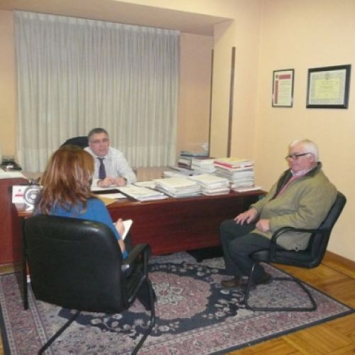 Asesor atendiendo a dos clientes en despacho