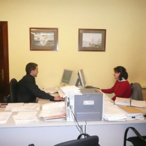 Dos trabajadores trabajando en mesas uno frente al otro