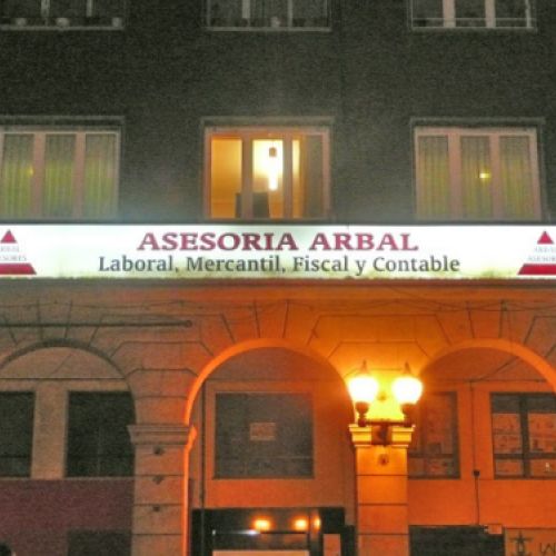 Fachada con letrero de asesoría de noche