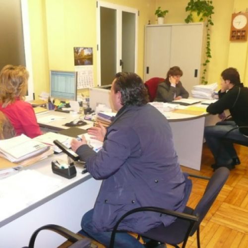 Interior de la oficina con trabajadores y clientes